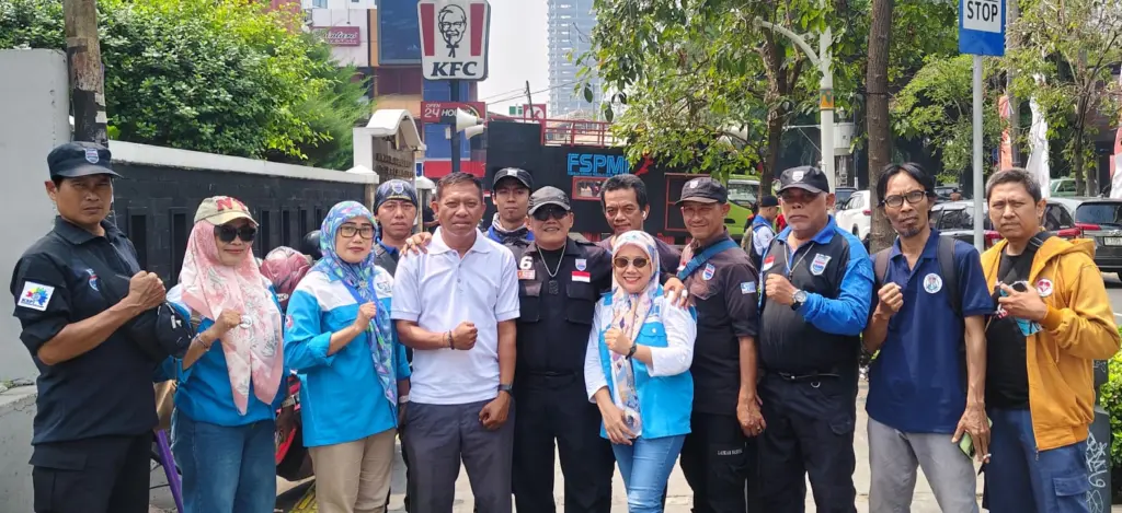 Sejumlah buruh berfoto bersama di trotoar sambil mengepalkan tangan