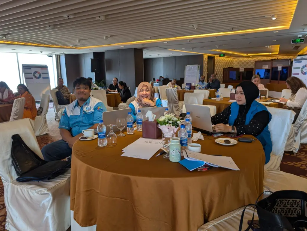 Peserta SPN berseragam biru duduk di meja bundar dengan laptop dalam ruang workshop hotel