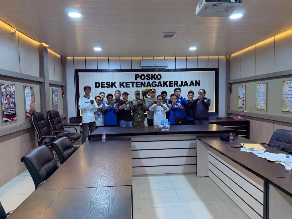 Pengurus SPN berfoto bersama petugas di depan papan Posko Desk Ketenagakerjaan
