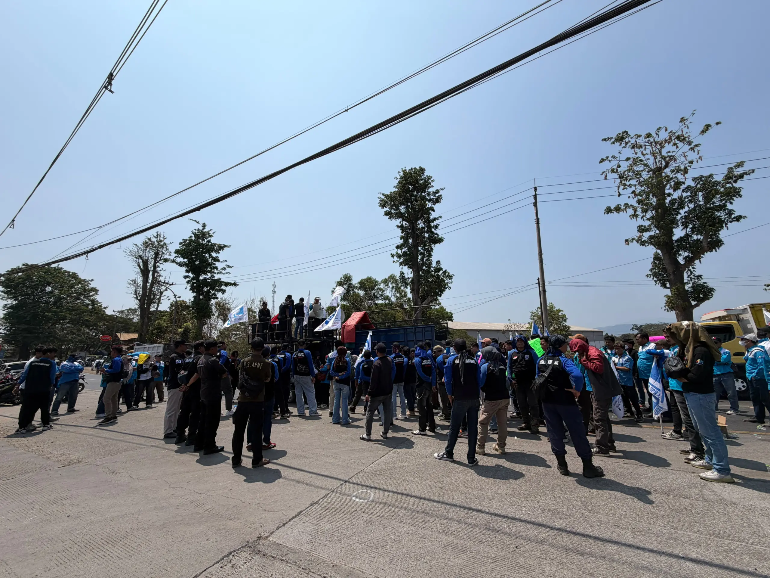 Barisan Laskar Nasional SPN berseragam biru hitam berdiri di depan mobil komando