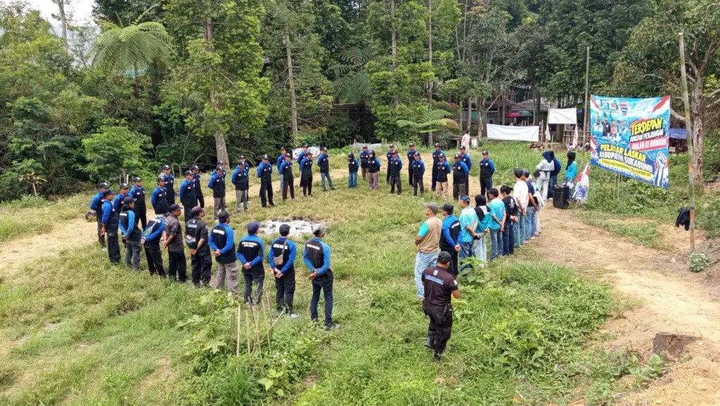 Barisan anggota Laskar Nasional berdiri membentuk lingkaran di lapangan berumput